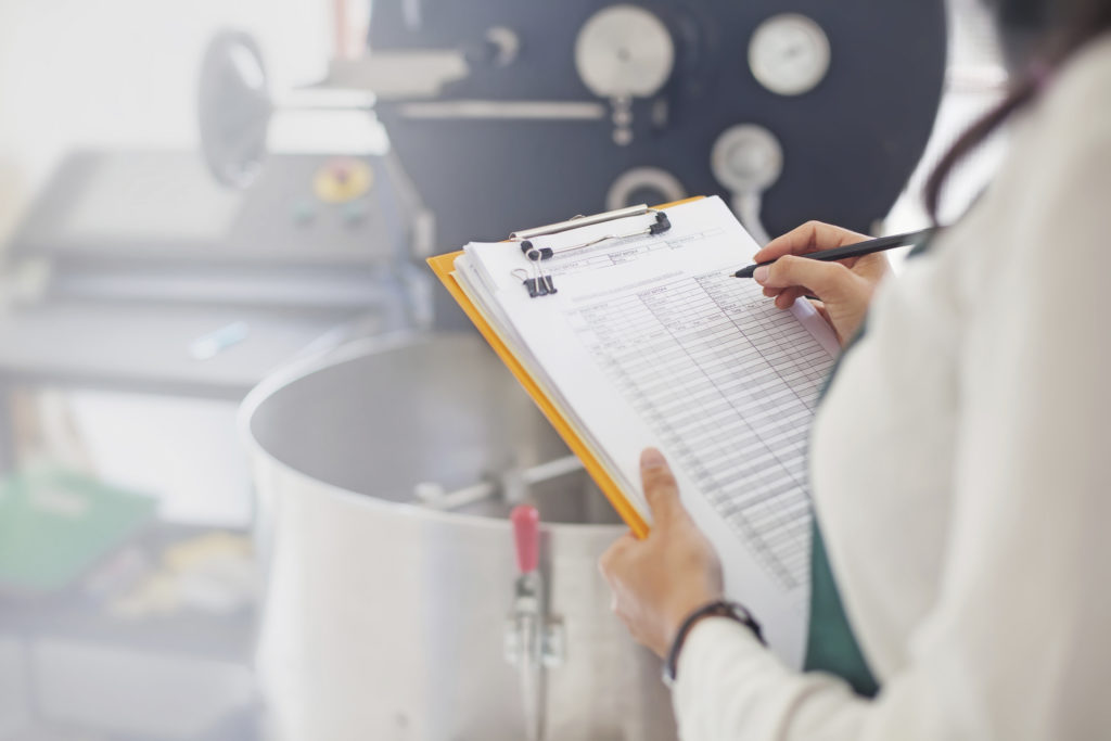 Woman in lab writing on a chart