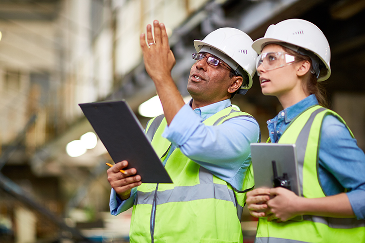 Construction surveyors looking up to building