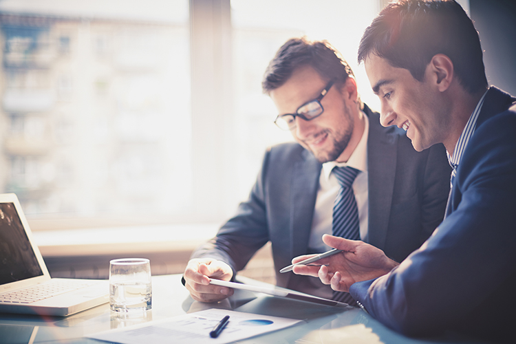 Businessmen at desk looking over a piece of paper