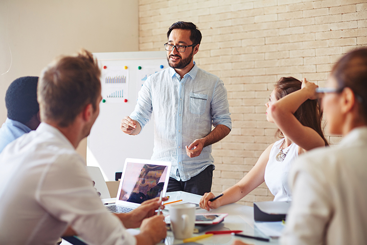 Man presenting to people sitting at a table