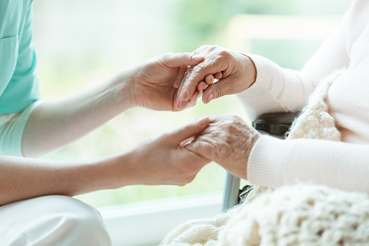Carer holding an elderly person's hands