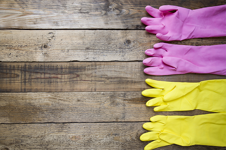 Yellow and pink rubber gloves on wooden table