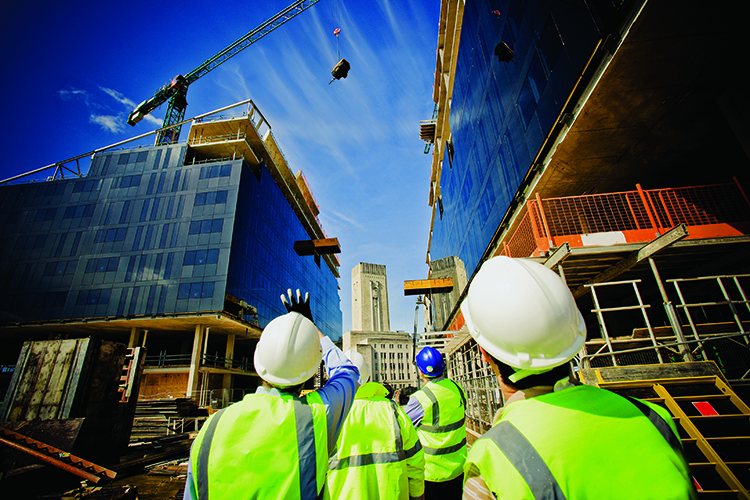 Construction workers standing in front of building under construction