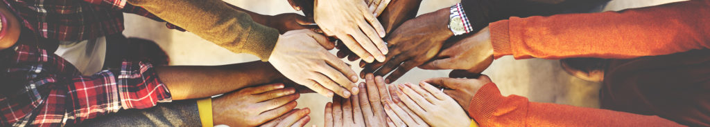 Young people in a circle putting hands together