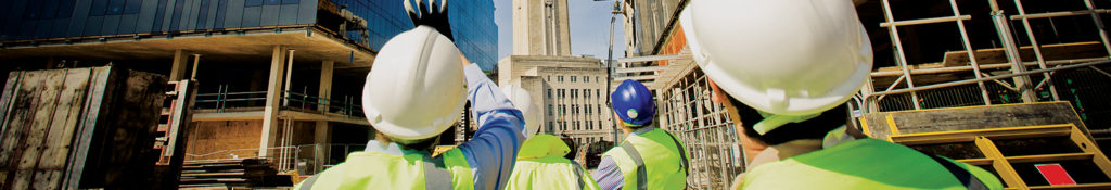 Construction workers standing in front of building under construction