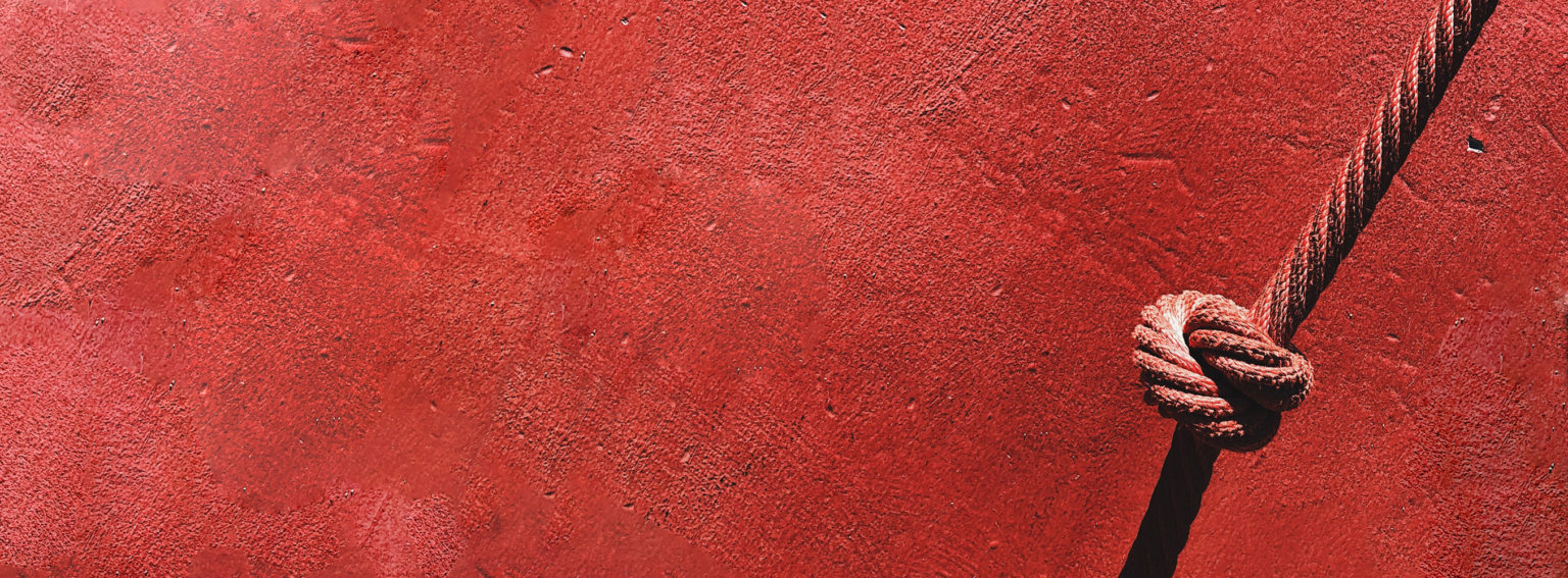 Rope with knot in front of red wall