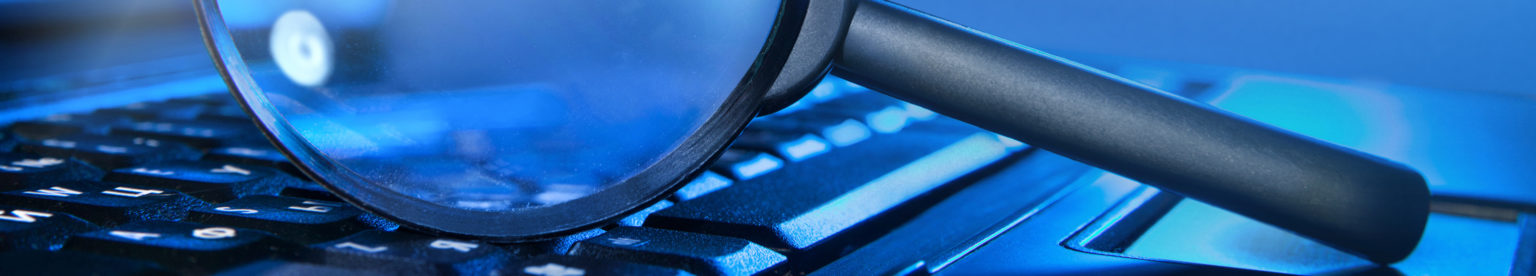 Magnifying glass on laptop keyboard