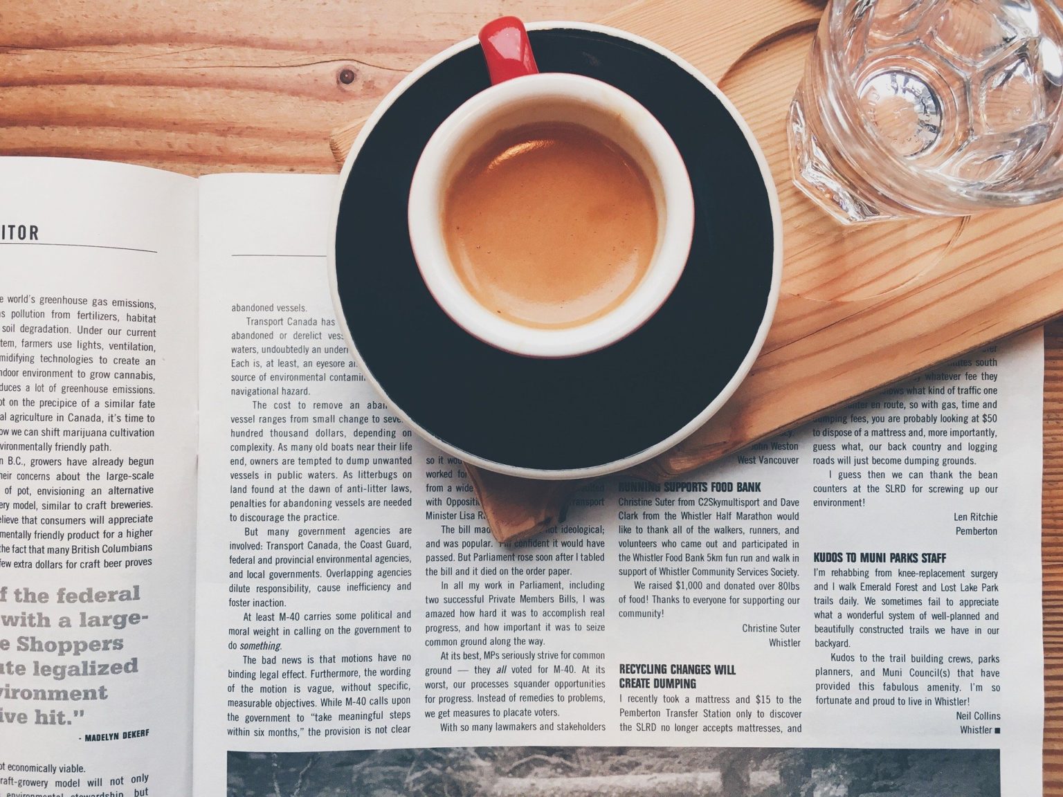 Cup of coffee on table with newspaper